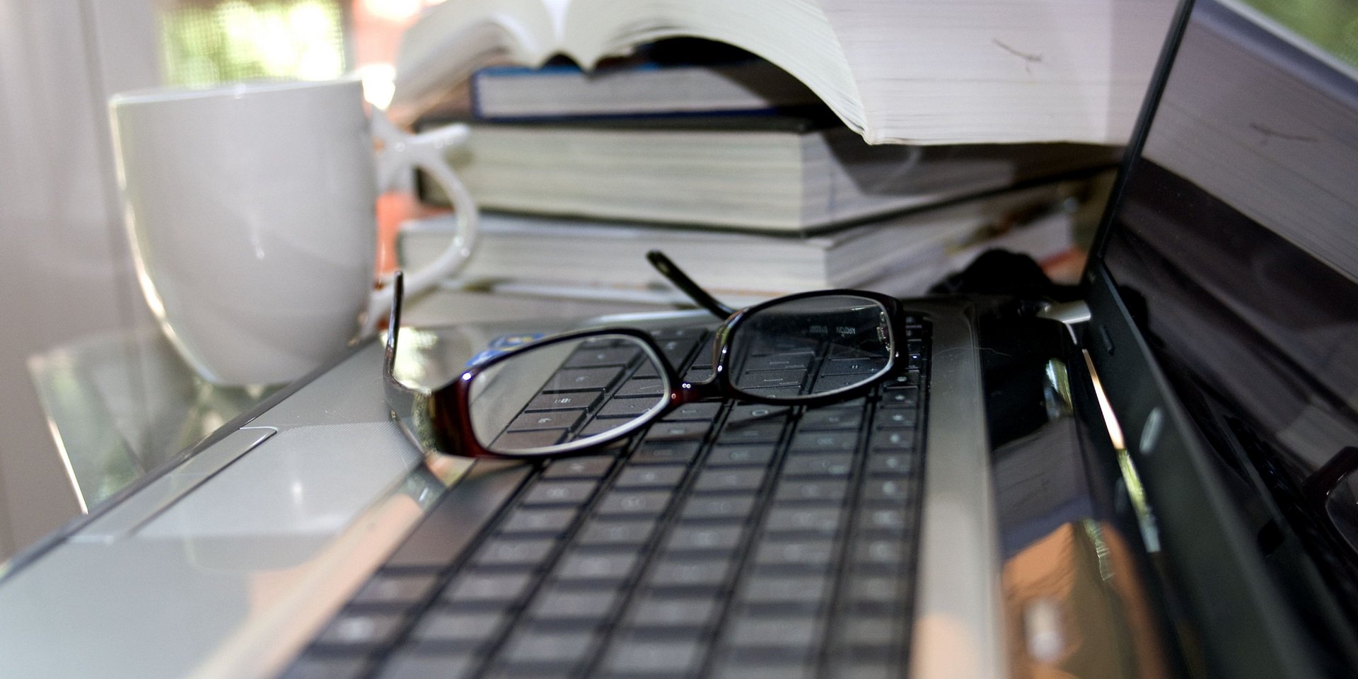 Blick auf einen Arbeitsplatz mit Büchern und PC