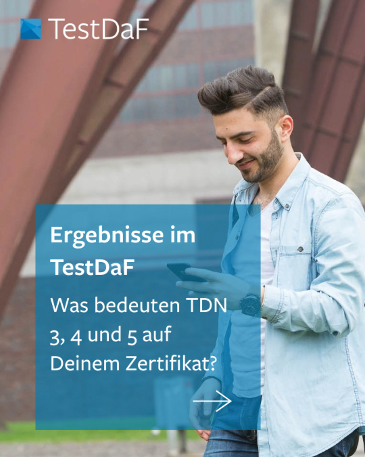 Ein junger Mann steht vor der Zeche Zollverein und schaut auf sein Mobilgerät.