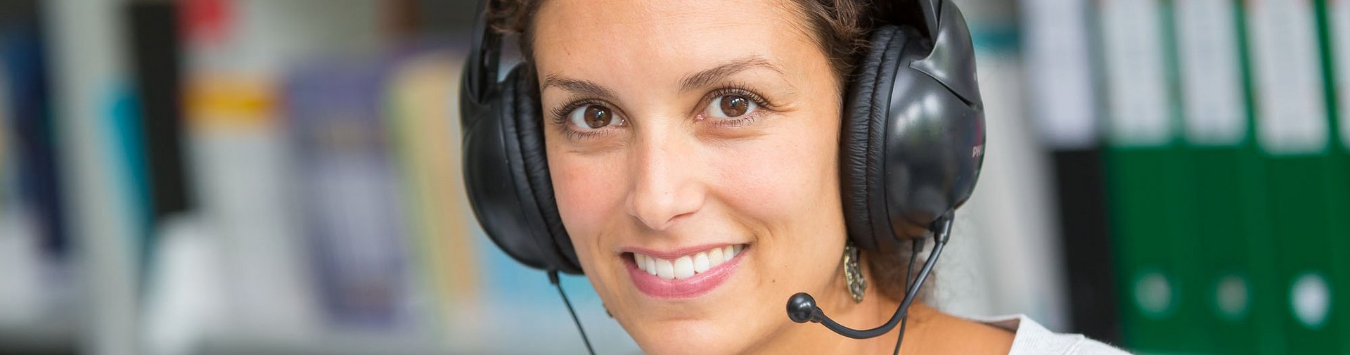 Studentin mit Headset in einer Bibliothek