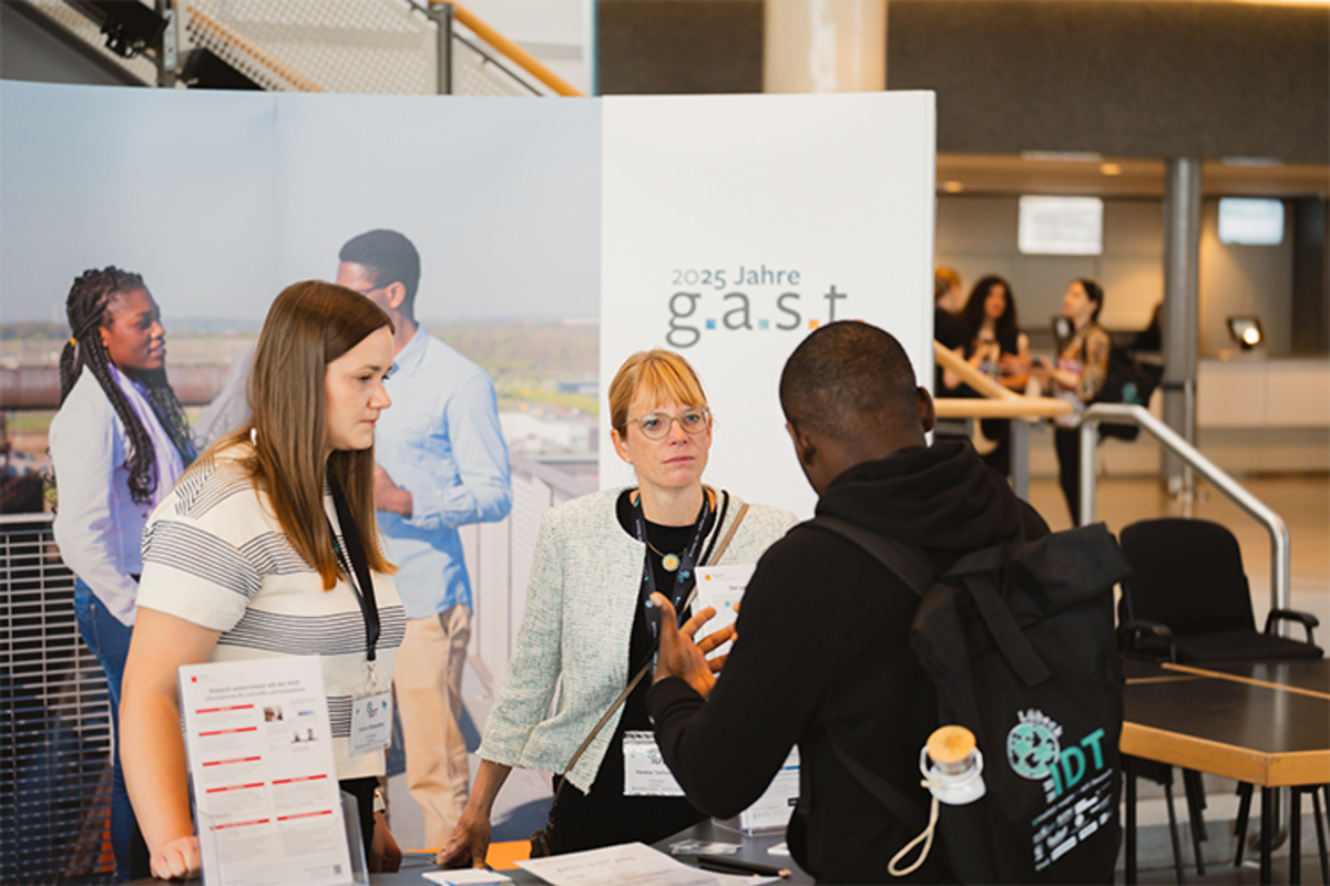 Zwei Mitarbeiterinnen des g.a.s.t.-Teams beraten am g.a.s.t.-Messestand auf der IDT 2025